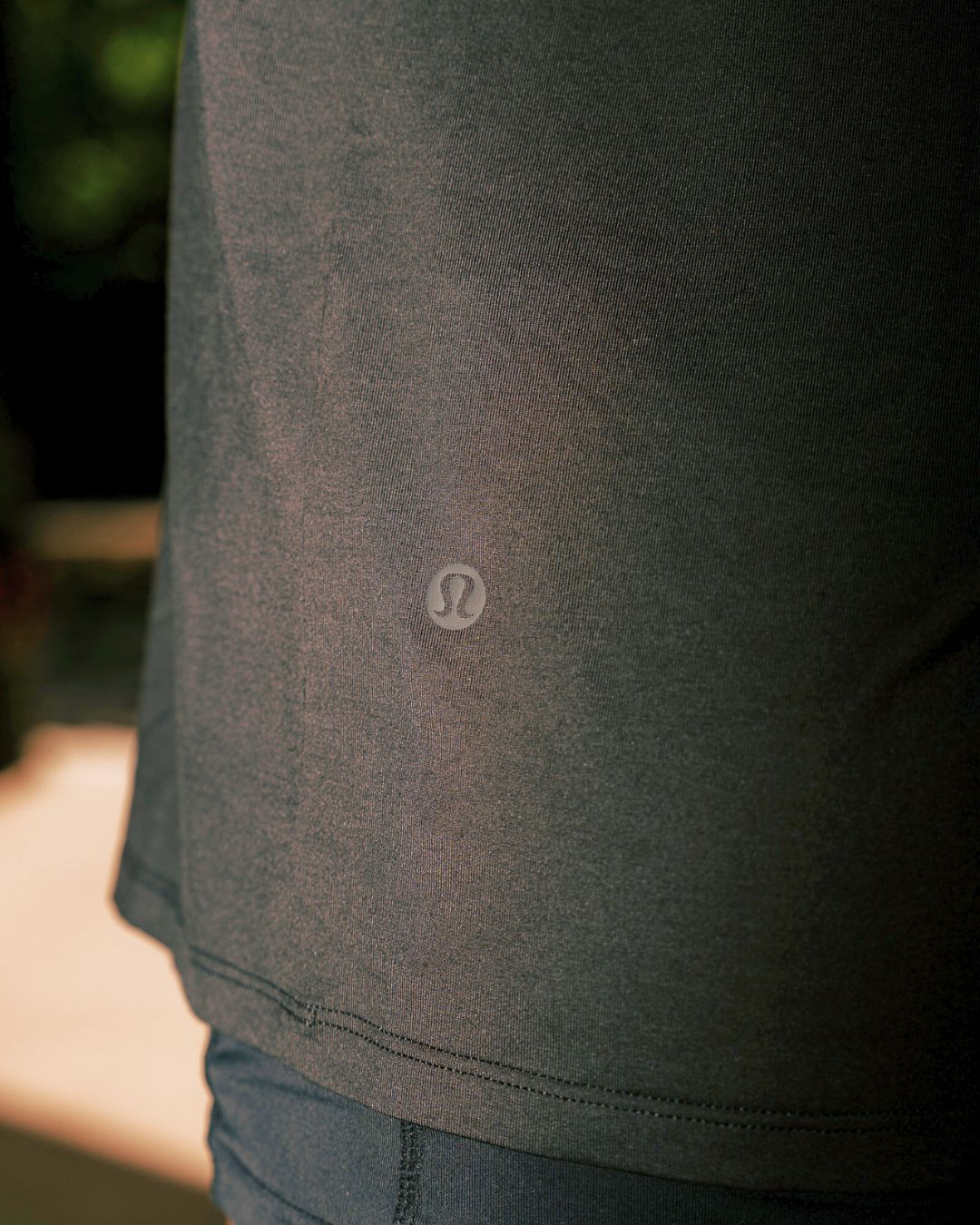 Close up shot Lululemon logo on the Black EXALT x Lululemon Fundamental Tee.